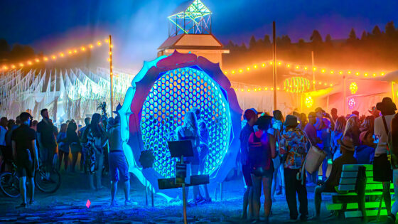 Festival attendees gather near an art installation in 2023