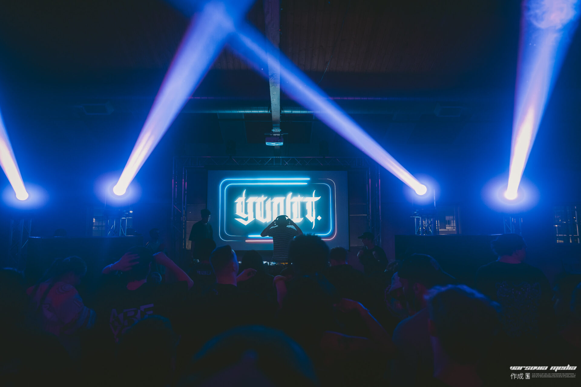 Yunit performing at the Freight House with blue lights and his logo on screen