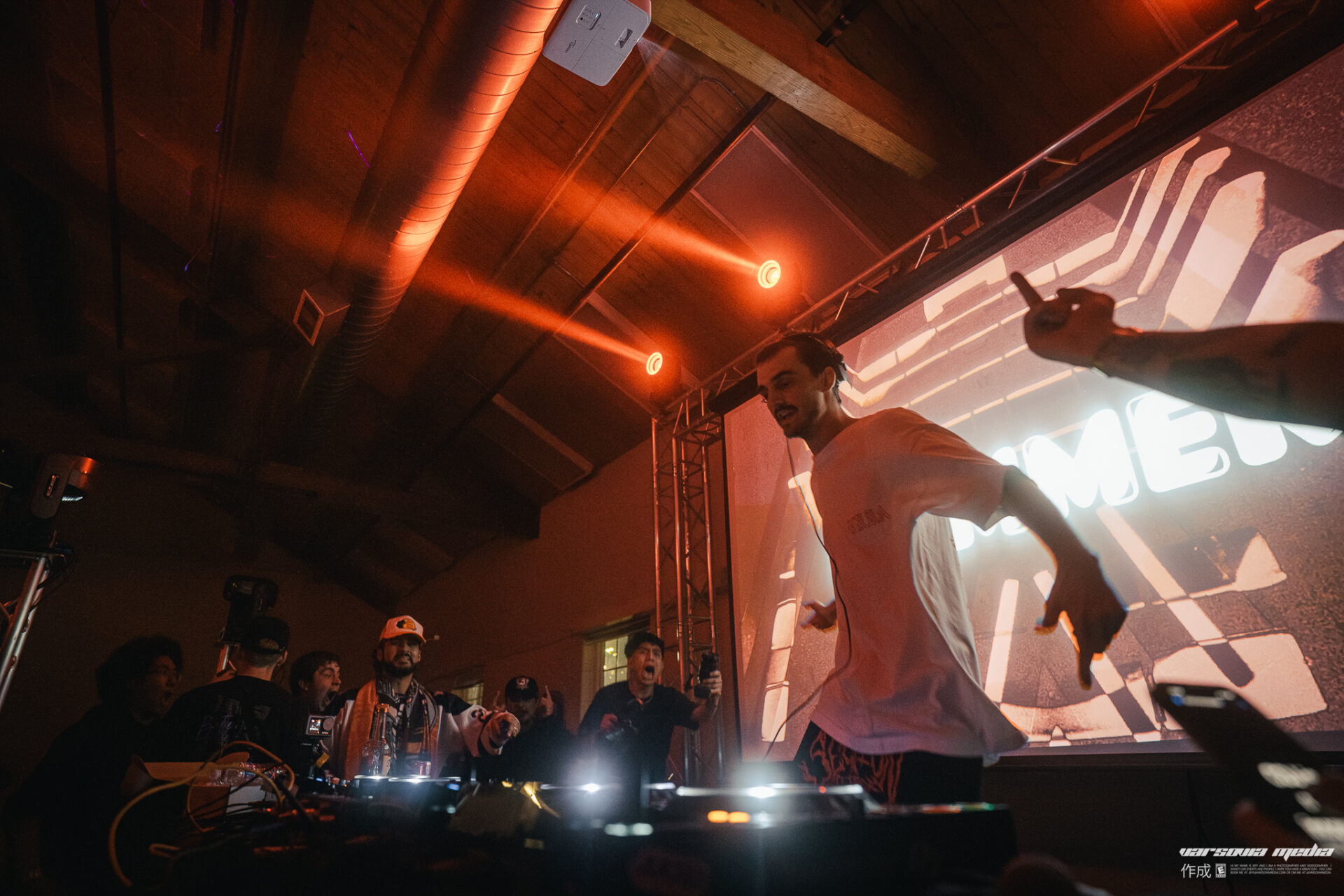 Bommer performing at the Freight House with red lights and his logo on screen