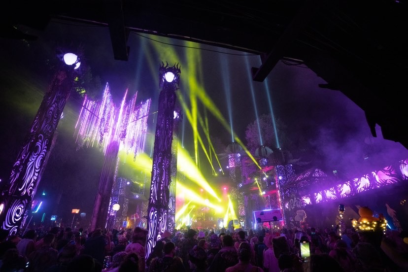 Village stage wide show with lit columns and chandelier in blue and green